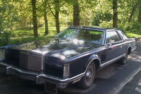 1991 Ford LTD Crown Victoria - This Lincoln Continental Mark V coupe is parked on a paved surface with trees in the background.