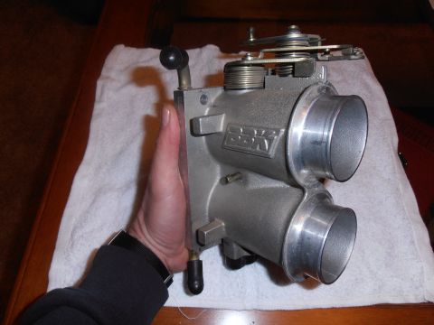 1990 Ford Bronco - A BBK throttle body is shown, held by a hand for scale and detail.