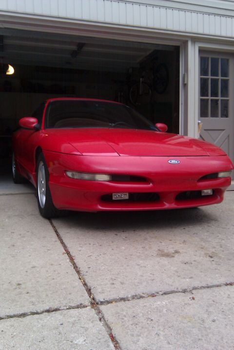 1996 Ford Probe - A red 1996 Ford Probe is parked in a driveway in front of an open garage door.