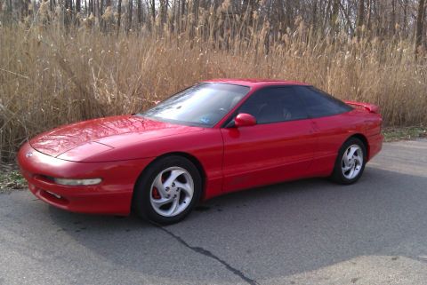 1996 Ford Probe - A red 1996 Ford Probe is shown from the front three-quarter view, parked outdoors.