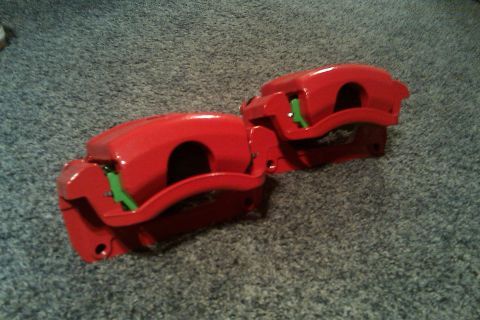 1996 Ford Probe - Pair of red brake calipers shown on a carpeted floor.