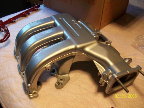 1996 Ford Probe - A silver intake manifold and red fuel rail are shown on a surface.