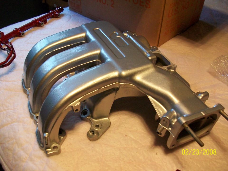 Silver intake manifold with red fuel rail in background