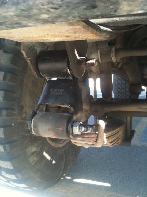 1990 Chevrolet Suburban - Underside view of a vehicle's suspension system, focusing on the leaf springs and shock mount.