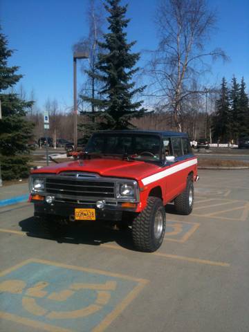 1990 Chevrolet Suburban - This red Jeep Wagoneer is parked in a handicapped spot, a two-tone paint scheme and off-road tires.