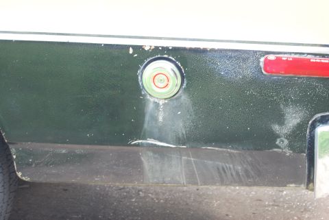 1975 Ford Ranchero - Close-up of a vehicle's side panel, showing a fuel door and part of a taillight, with visible wear and tear.