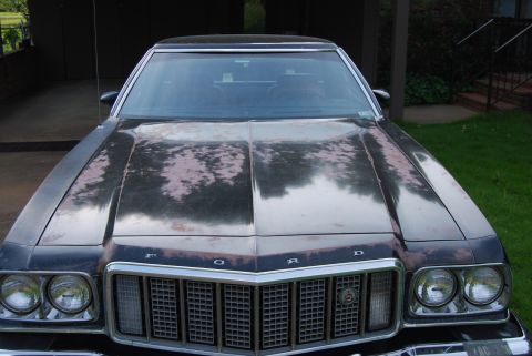 1975 Ford Ranchero - The front of a 1975 Ford Ranchero shows significant paint deterioration on its hood and front grille.