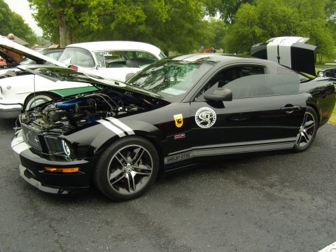 2007 Ford Mustang - A black Ford Mustang Shelby GT500 is parked with its hood open, displaying the engine.