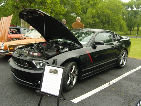 2007 Ford Mustang - A black 2012 Ford Mustang GT is displayed with its hood open, revealing the engine and a descriptive sign.