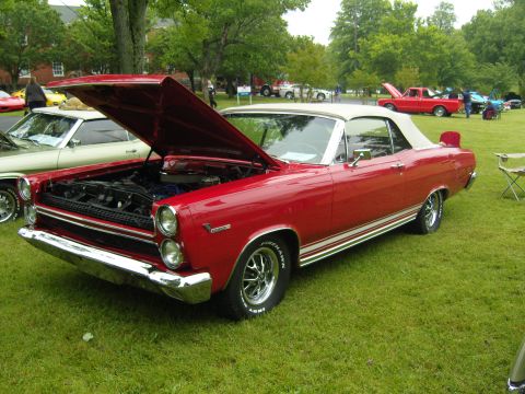 2007 Ford Mustang - A classic red convertible is displayed with its hood up at an outdoor car show.