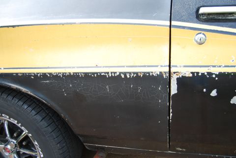 1975 Ford Ranchero - Side panel of a 1975 Ford Ranchero with significant paint wear and rust.