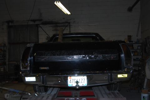 1975 Ford Ranchero - Rear view of a black 1975 Ford Ranchero parked indoors on a lift.