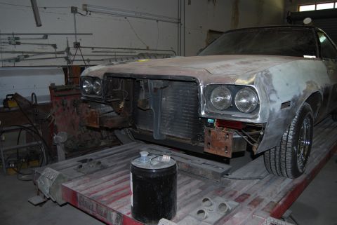 1975 Ford Ranchero - This 1975 Ford Ranchero is in a workshop, showing its front end with the grille missing and bodywork in progress.