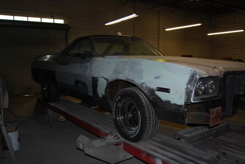 1975 Ford Ranchero - This 1975 Ford Ranchero is undergoing bodywork, showing its primer finish and being supported by a lift.
