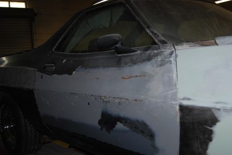 1975 Ford Ranchero - Side view of a car door undergoing bodywork, with visible rust.