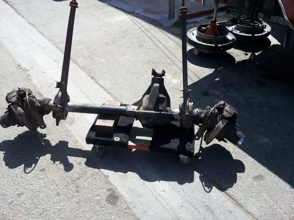 Dana 60 axle assembly on a creeper dolly, with brake drums in background