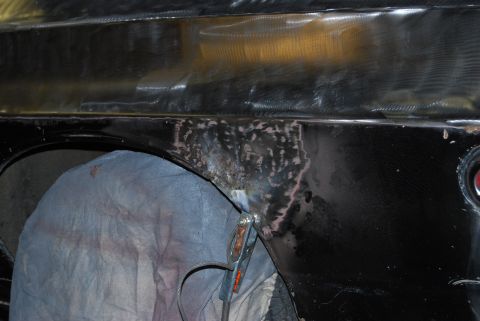 1975 Ford Ranchero - Welding clamp attached to a car's fender during body repair work.
