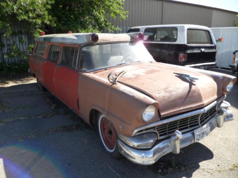 1994 Jeep Cherokee - This vintage ambulance, possibly a Ford, shows significant rust and wear, parked outdoors.