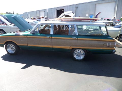 1994 Jeep Cherokee - Station wagon with wood paneling and surfboards on the roof is parked outside a building.