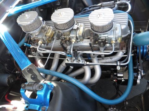 1994 Jeep Cherokee - Close-up of a custom engine triple carburetors and vibrant blue engine bay components.