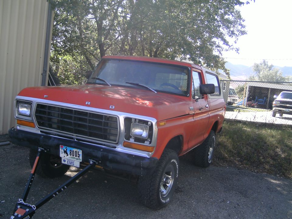 Red 1979 Ford Bronco with a tow bar attached