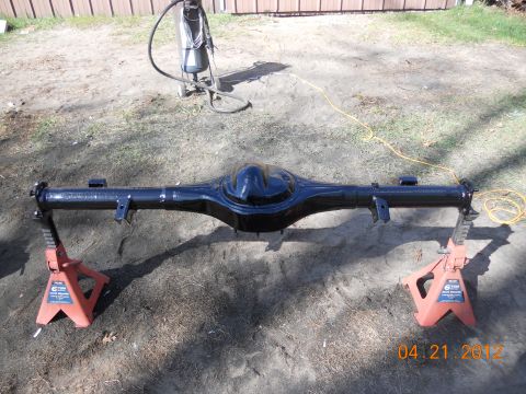 1978 Ford Bronco - A black rear axle assembly is shown on jack stands outdoors, with a sandblaster visible in the background.