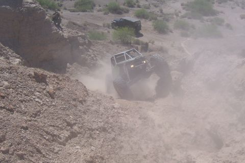 1981 Ford F-150 - An off-road buggy navigates a steep, dusty incline while another vehicle watches from above.