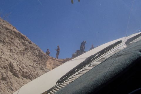 1981 Ford F-150 - People gathered on a sandy ridge, viewed from the interior of a vehicle.