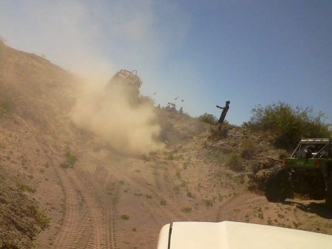 1981 Ford F-150 - Multiple off-road vehicles navigate a steep, dusty dune under a clear blue sky.