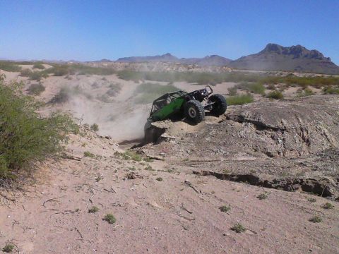 1981 Ford F-150 - An off-road buggy navigates a challenging rocky incline in a desert landscape.