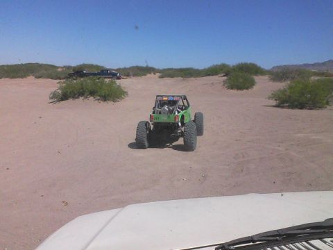 1981 Ford F-150 - A custom off-road buggy is seen in a sandy desert environment with other vehicles present.