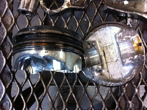 1990 Ford Bronco - These engine pistons show significant damage, indicating a catastrophic engine failure.