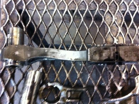 1990 Ford Bronco - A close-up view of a greasy automotive part and a socket on a metal grate.