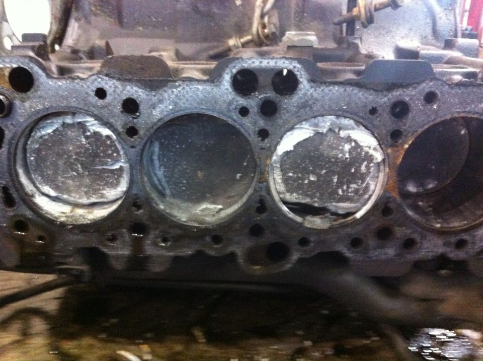 Engine block with four damaged pistons visible
