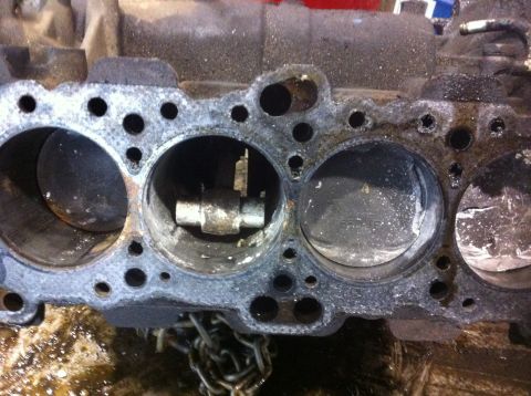 1990 Ford Bronco - Close-up view of a damaged engine block, revealing pistons within the cylinders.
