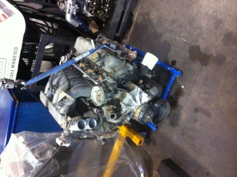 1990 Ford Bronco - Engine on a stand, possibly a Ford 351 Windsor, in a workshop environment.