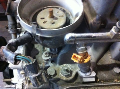 1990 Ford Bronco - Engine component detail, likely a fuel injector and part of the ignition system.