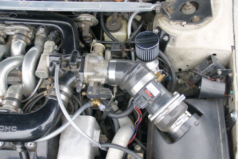 1993 Ford Taurus - Close-up of the engine bay of a 1993 Ford Taurus, showing the engine components and an aftermarket air intake system.