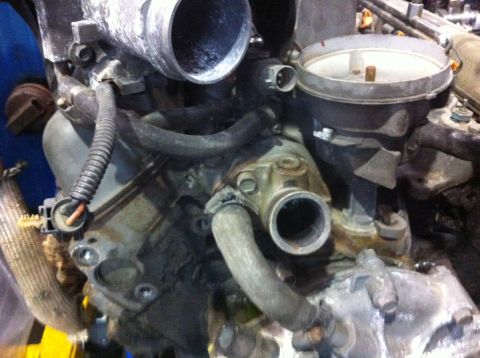1990 Ford Bronco - Close-up view of engine components, including intake manifold and hoses, with Supermotors.net logo visible.
