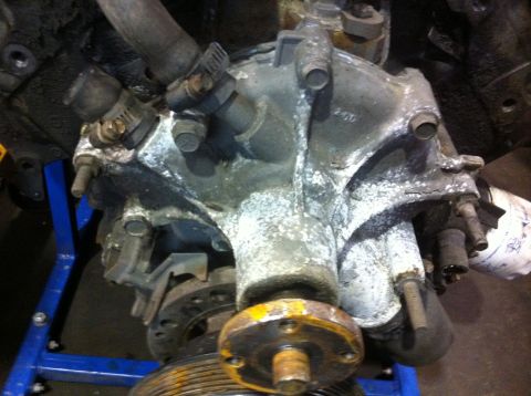 1990 Ford Bronco - Close-up of an engine water pump assembly, showing signs of wear and corrosion.
