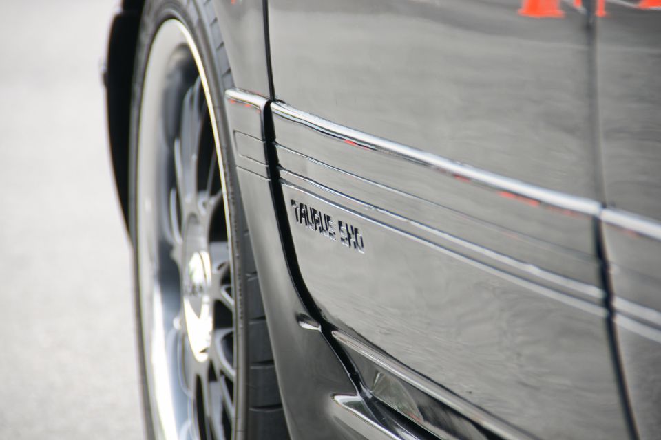 Close-up of 1993 Ford Taurus SHO emblem on the side panel next to the wheel