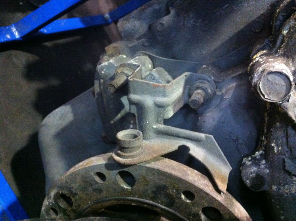 close-up of a rusty engine bracket and part of a brake rotor