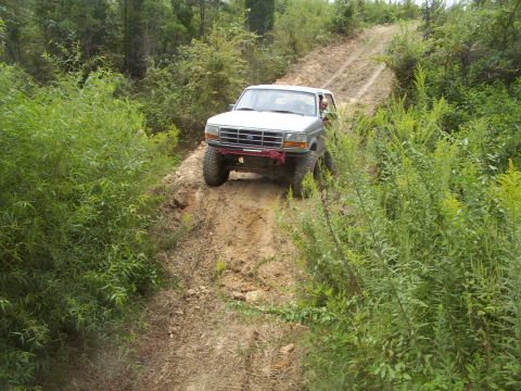 1995 Ford Bronco - This 1995 Ford Bronco navigates a challenging off-road trail, its capability on rough terrain.