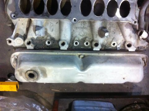 1990 Ford Bronco - Close-up of a Ford engine intake manifold, possibly from a 351W build, with visible part numbers and casting marks.
