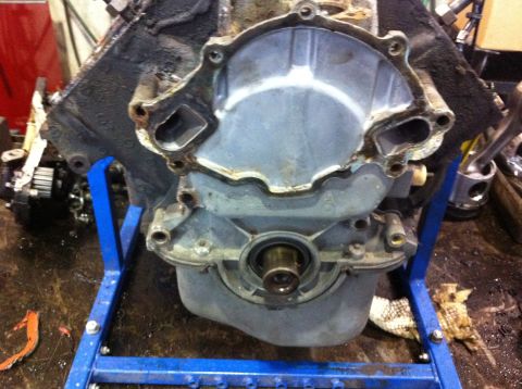 1990 Ford Bronco - Close-up of an engine block on a stand, with the timing cover removed to expose internal components.