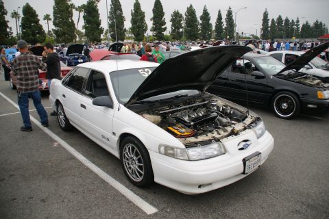 1993 Ford Taurus - A white 1993 Ford Taurus is displayed with its hood open at an outdoor car event.