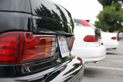1993 Ford Taurus - A line of cars parked in a lot, with the rear of a black car in the foreground.