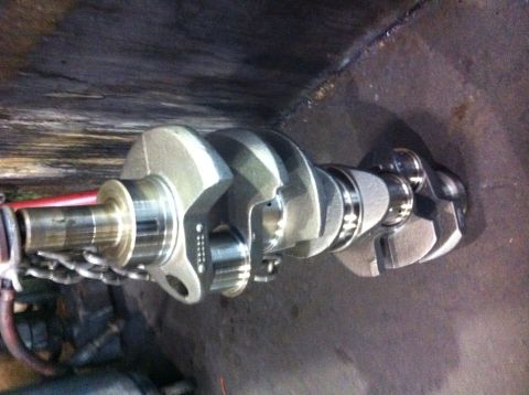 1990 Ford Bronco - A close-up view of a metal crankshaft, a key component of an engine's rotating assembly.