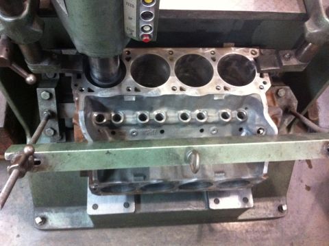 1990 Ford Bronco - Engine block undergoing machining work, with visible cylinders and oil passages.