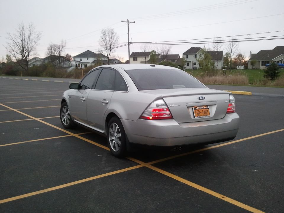 Silver Ford Taurus sedan parked in a striped lot